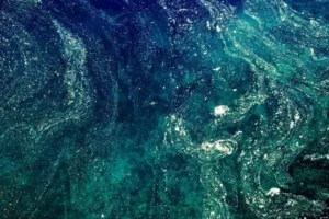 An aerial view of the ocean with green and blue waves.